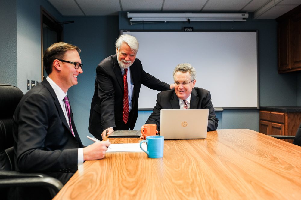 Three lawyers in an meeting discussing a free case assessment