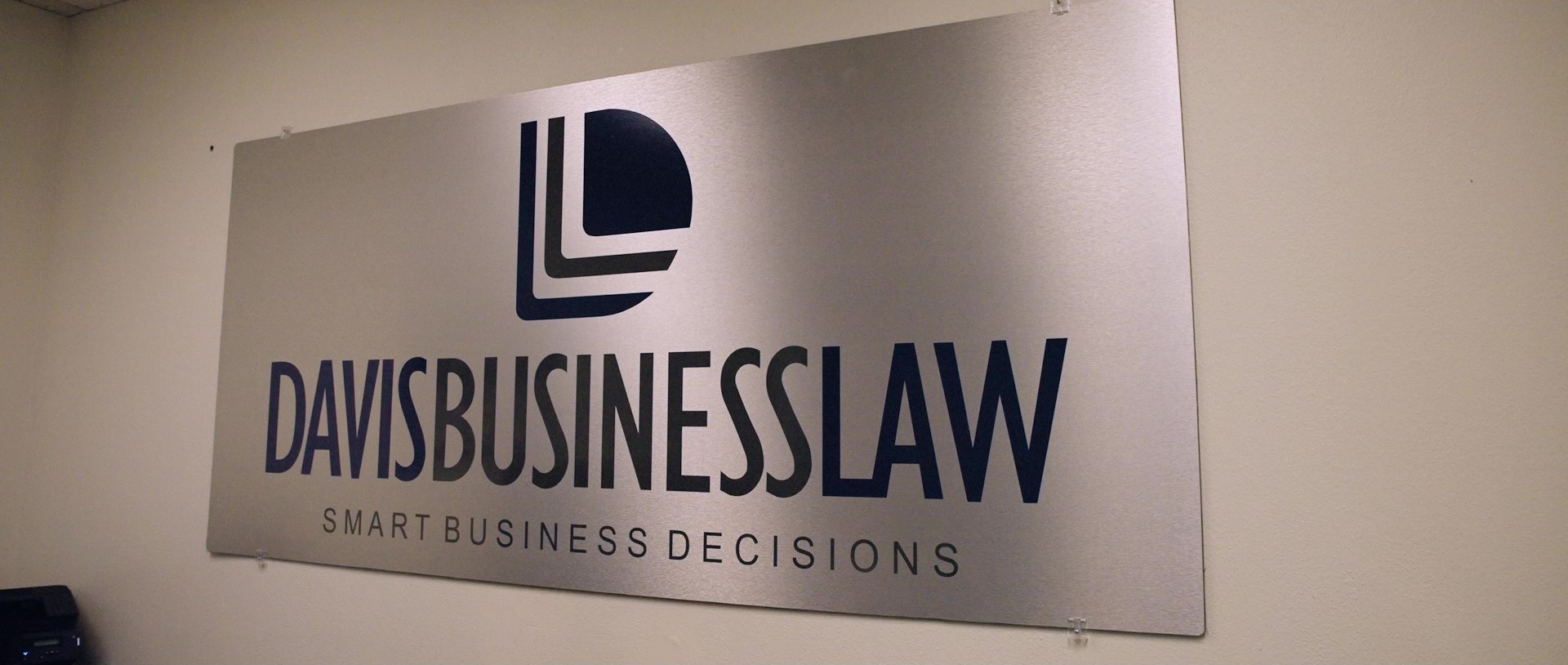 Metallic sign that reads Davis Business Law