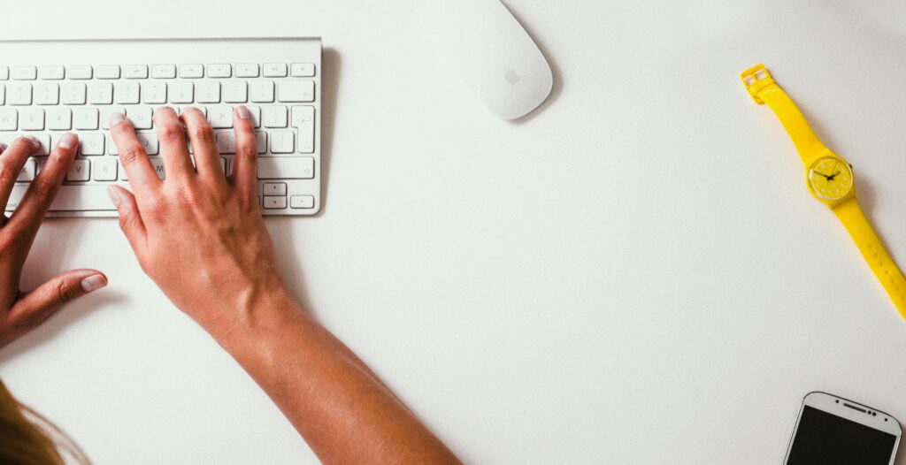 Person typing on Apple wireless keyboard