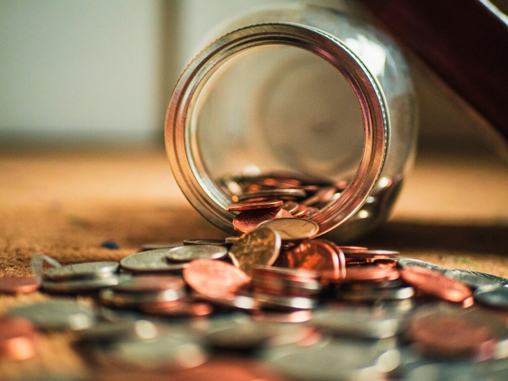 Coins falling out of a turned over mason jar