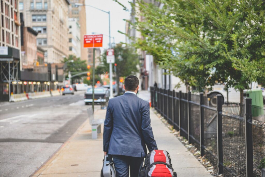 Person in a suit walking down a sidewalk