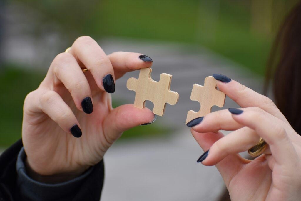 Person putting two puzzle pieces together