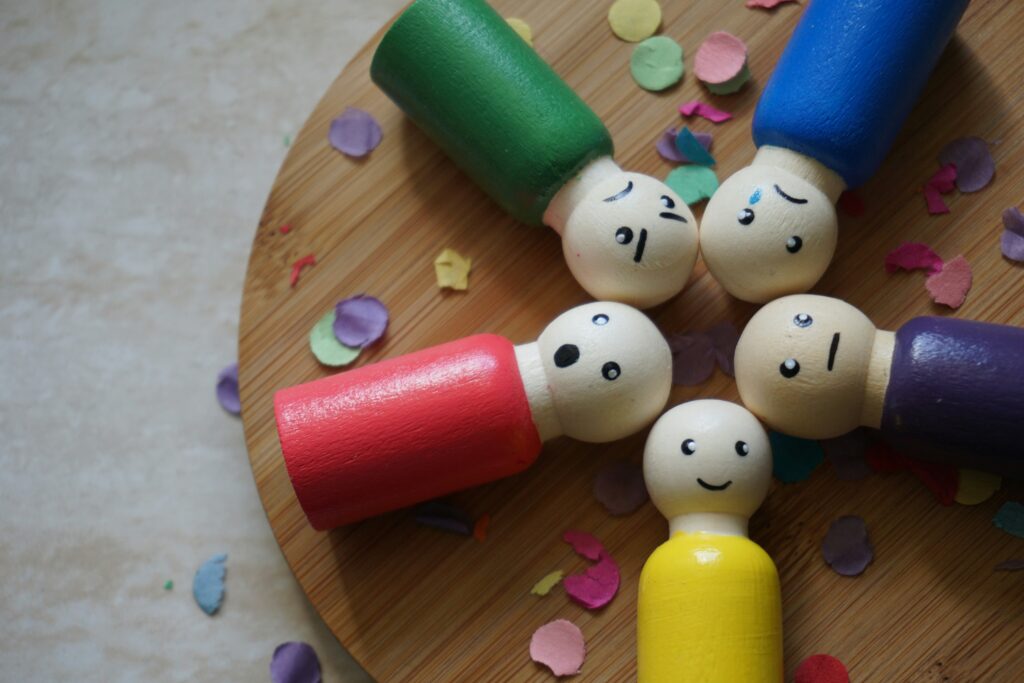 Five wooden toys with different facial expressions