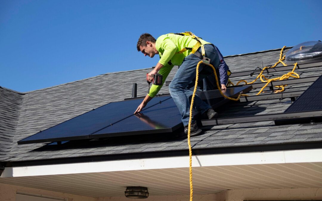 man installing a residential rooftop solar panel